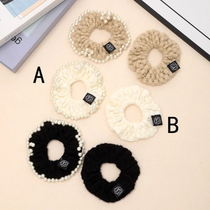 Detail of six-piece knitted pearl scrunchie set in beige, cream, and black colors
