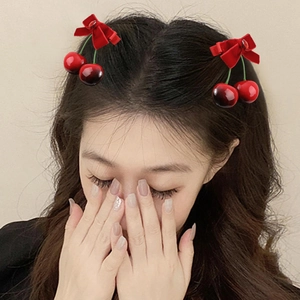 Paire de barrettes cerises en velours rouge avec nœud en tissu sur mannequin
