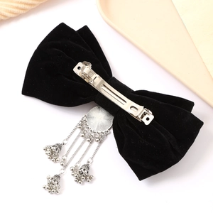 Elegant red velvet bow hair clip with silver tassel bells for a bridal toast look