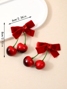 Détail montrant les dimensions 6x8cm d'une barrette cerise en velours rouge sur plateau