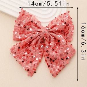 Detailed size view of a 14x16cm pink sequined bow hairclip on a neutral textured surface