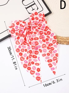 Detail of oversized white bow hair clip with red lip print and long flowing streamers