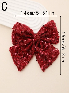 Macro view of handmade red sequined bow hairclip showing 14cm by 16cm dimensions