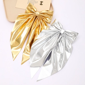 Elegant metallic bow hair clips in gold and silver with long hanging ribbons