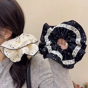 Detailansicht großer schwarz-beiger Polka-Dot Samt-Haargummis mit weißem Spitzenrand