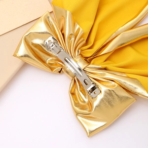 Elegant gold bow hair clip with silver spring metal fastener and long ribbon detail