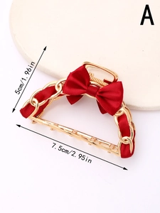 Detail of red bow hair claw clip with golden chain and silk fabric, size 7.5cm by 5cm