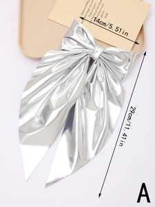 Detail showing 14cm width and 29cm length of the large silver metallic bow hair clip