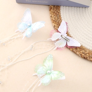 Tre fermagli a farfalla con perle e nappe di perline nei colori blu, viola e verde pastello