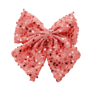 Handmade large sequined bow hair clip in salmon pink with a shiny metallic finish