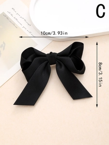 Détail d'une barrette à nœud en ruban satin noir avec dimensions et texture du tissu