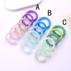 Detailed view of colorful spiral telephone wire hair ties with star and polka dot patterns