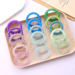 Close-up of colorful spiral telephone wire hair ties in a tray with cute star patterns