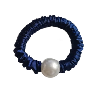 Close-up of navy blue satin hair tie featuring a single large white pearl ornament
