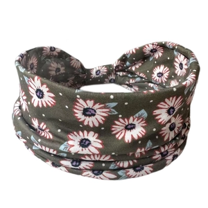 Close-up of elastic cotton headband with white daisy print and twisted knot design