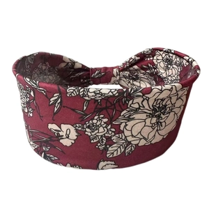 Close-up of bohemian wide headband with white floral pattern on wine red fabric