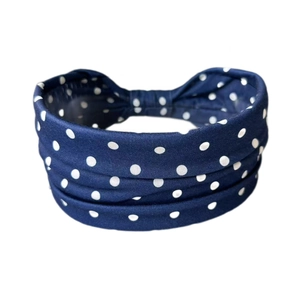 Détail d'un bandeau de sport élastique bleu marine à pois blancs avec tissu plié