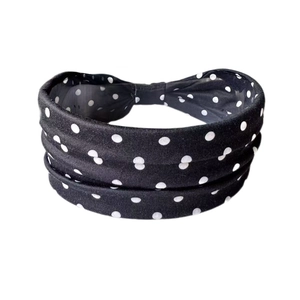 Détail macro du bandeau large élastique à pois noirs et blancs avec un nœud central