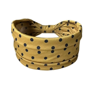 Détail du bandeau jaune moutarde à pois noirs avec un design élégant de nœud arrière