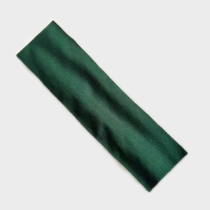 Detailed view of the dark green elastic yoga headband with ribbed knitted texture