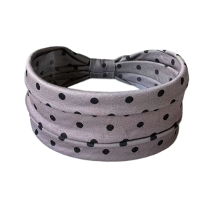 Détail d'un bandeau large gris à pois montrant le tricot extensible et l'effet froncé