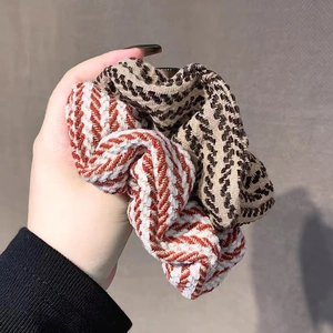 Set of two stylish knitted scrunchies with wavy orange and plaid patterns for women