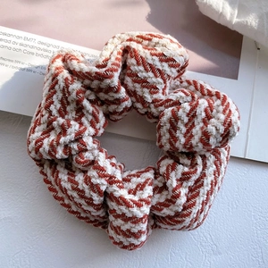 Detailed view of large knitted scrunchie with red and white herringbone stripe pattern