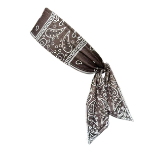 Detail of dark brown knotted sports headband with white paisley floral print texture