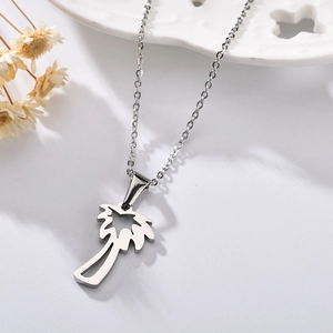 Elegant stainless steel necklace with hollow coconut tree pendant on marble background