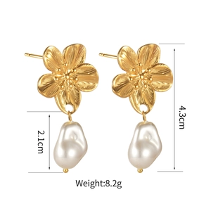 Detail view of 18K gold-plated floral earrings with textured petals and Baroque pearl drops