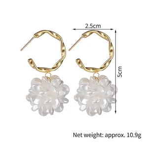 Detailed size view of gold twist hoop earrings with white floral resin charms