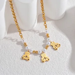 Détail du collier en chaîne dorée 18K avec perles blanches et trois oursons