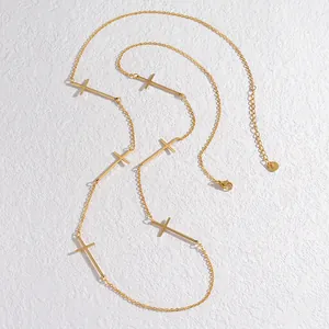 Minimalistische goldene Edelstahlhalskette mit mehreren Kreuzanhängern auf weißem Grund