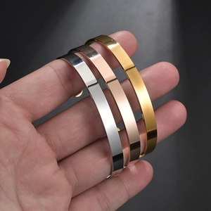Three minimalist stainless steel open C-shaped bracelets in gold, rose gold and silver