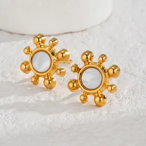 Boucles d'oreilles tournesol dorées minimalistes avec émail blanc sur fond de pierre