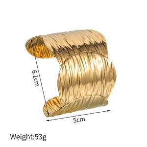 Detail view of gold wide cuff bracelet with 6.1cm height and vertical wavy texture