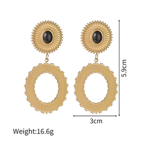 Vue macro des boucles d'oreilles ovales dorées montrant la hauteur de 5,9 cm