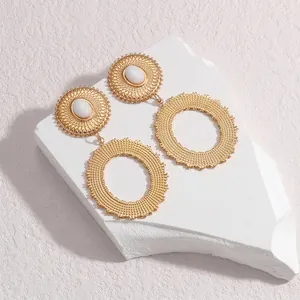 Boucles d'oreilles ovales géométriques dorées avec perle blanche sur support en marbre
