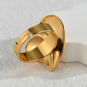 Unique irregular heart-shaped adjustable gold stainless steel ring on marble base