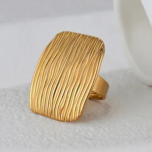 Minimalist gold plated stainless steel ring with a wide rectangular wavy textured surface