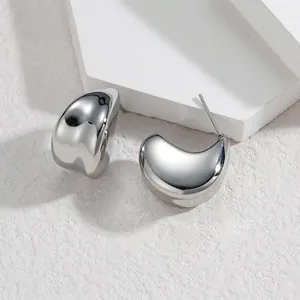Macro detail of silver C-shaped titanium steel earrings with high-polished mirror finish