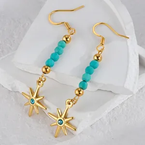 Détail de boucles d'oreilles étoile avec perles turquoise et zircon bleu sur pierre