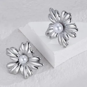 Detailed view of silver flower earrings featuring smooth white pearls and petal texture
