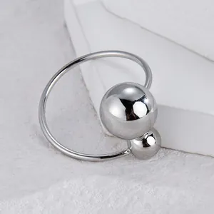 Détail d'une bague minimaliste en acier inoxydable avec deux billes sur surface en pierre