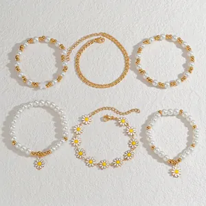 Set di 6 bracciali in oro e bianco con margherite, perle e catene a maglie eleganti