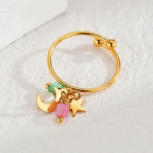 Detail of gold moon and star charms with colorful beads on a stainless steel open ring