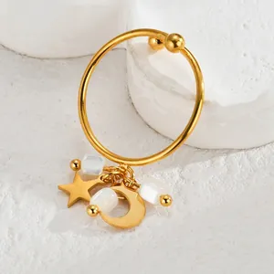 Detailed macro view of gold-plated star and moon tassels with white square stone beads