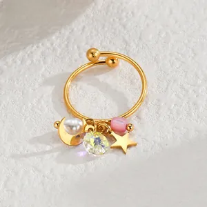 Detailed macro view of gold-tone charm ring featuring celestial moon and star pendants