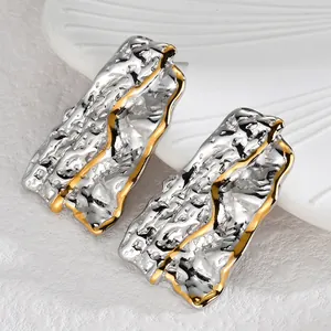 Detail of irregular geometric earrings with two-tone silver and gold hammered texture