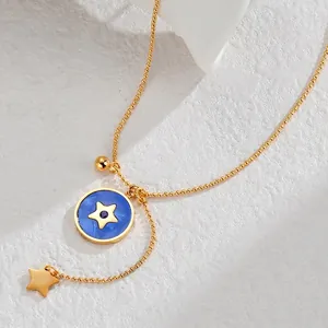 Macro d'un collier à perles dorées avec pendentif étoile émaillé bleu et breloque